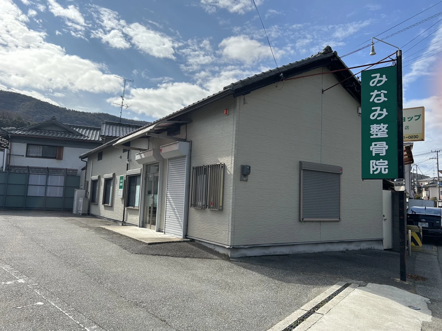 みなみ整骨院の外観。緑色の看板と建物前の駐車スペース